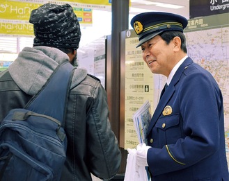 通行人に啓発品を渡す永野署長