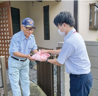 弁当を受け取る高齢者