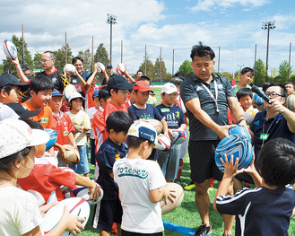 子どもたちにボールの持ち方を教える吉田氏