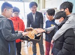 グローブを触る本町小学校６年１組の児童