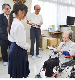 生徒会のメンバーに手渡す宅見さん（右）